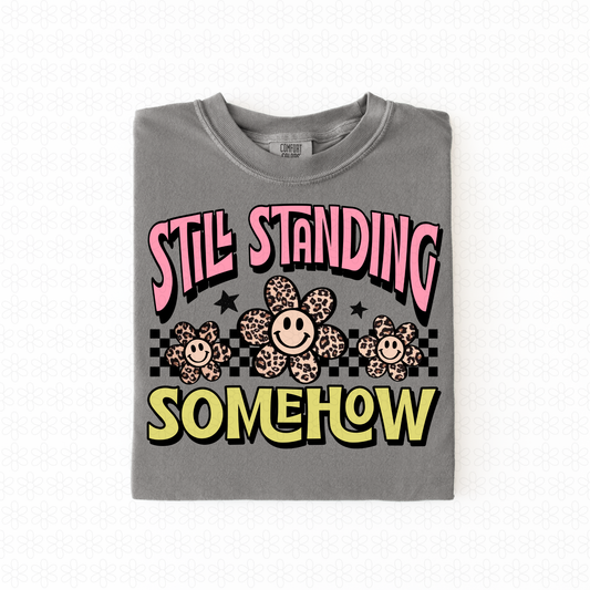 Still Standing Somehow Completed Tee